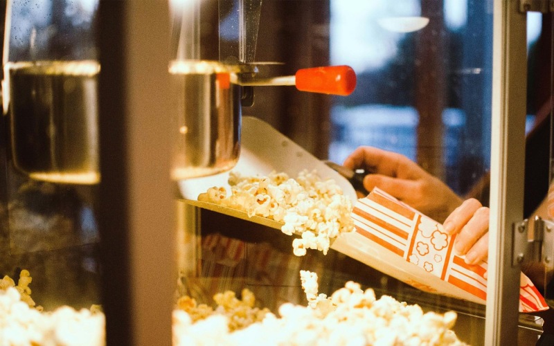 a person pouring popcorn into a container