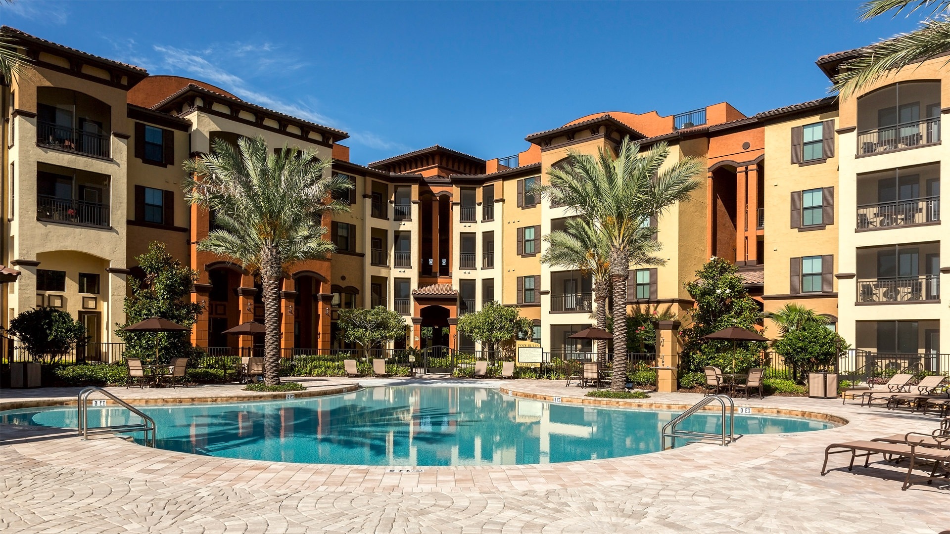An apartment with a resort-style pool and palm trees