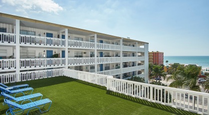 Open rooftop deck with grass and lounge chairs with harbor views