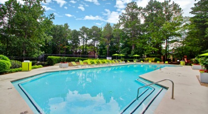 Large swimming pool surrounded by lounge chairs 