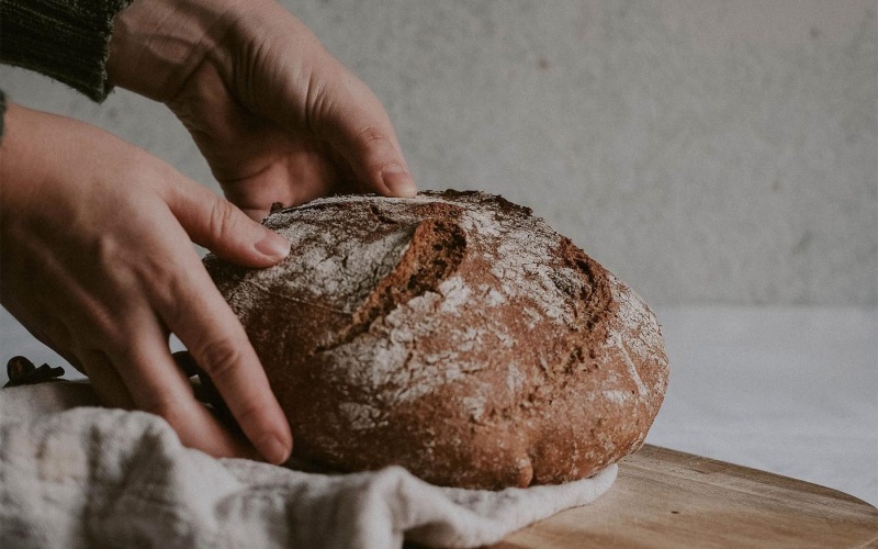 a person holding a loaf of bread