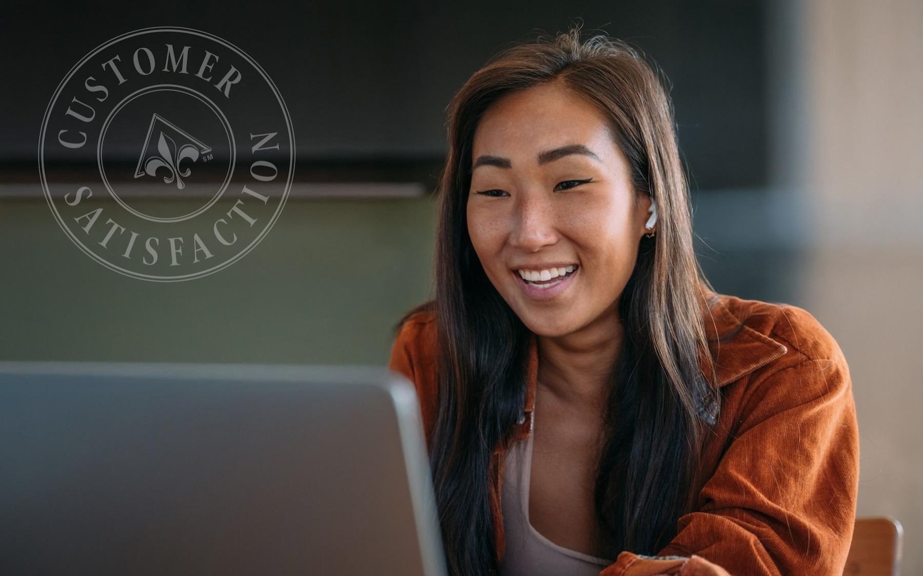 a woman smiling looking at a computer