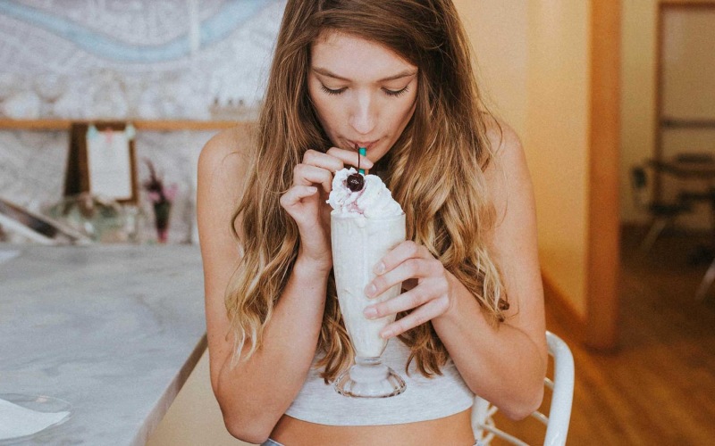 a woman drinking a milkshake