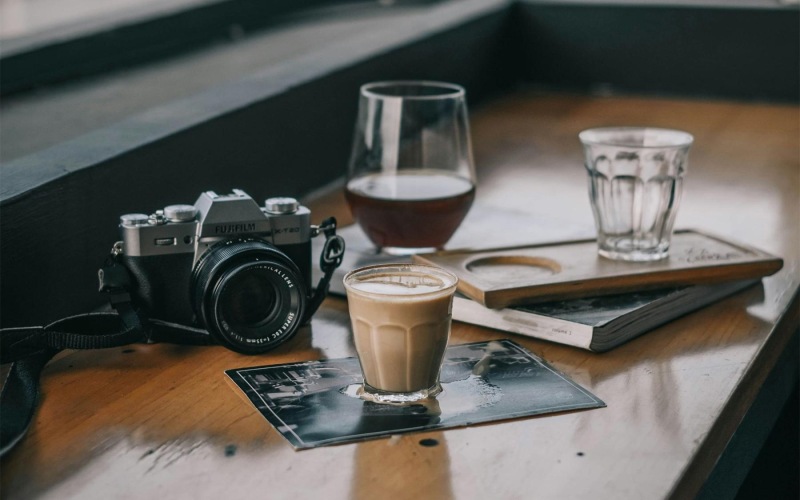 a camera and cup of coffee on a table