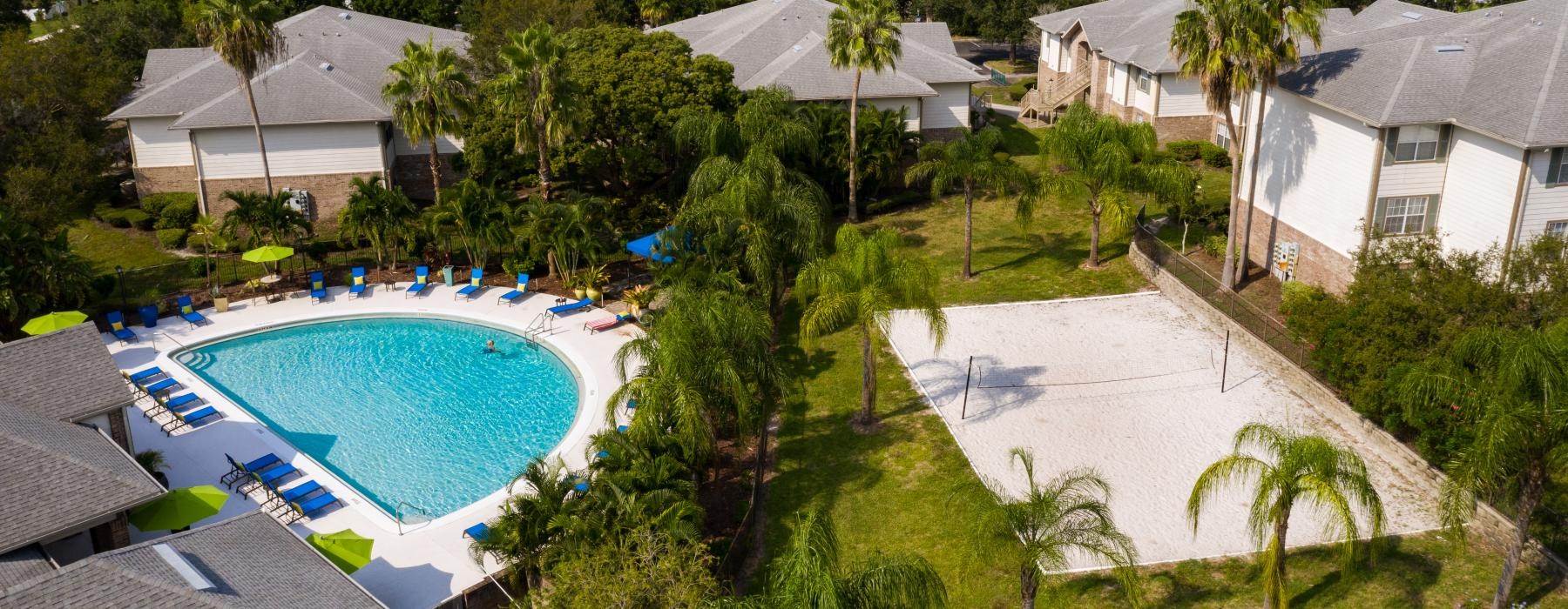 a pool surrounded by trees and buildings