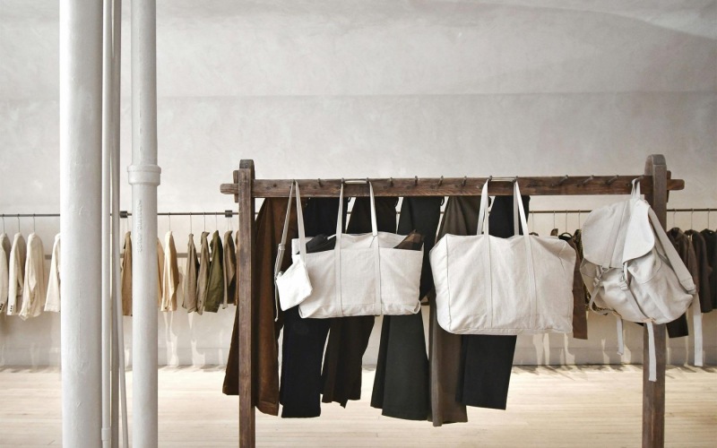 a row of clothes and bags on a rack