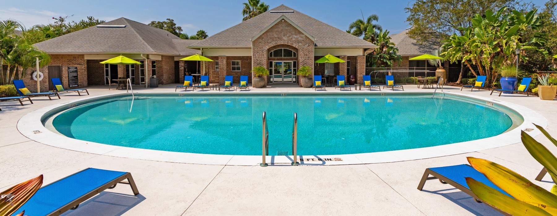 a swimming pool with a clubhouse in the background