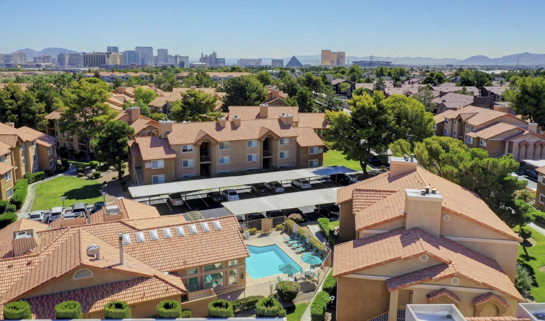 a group of buildings with trees and grass in the front