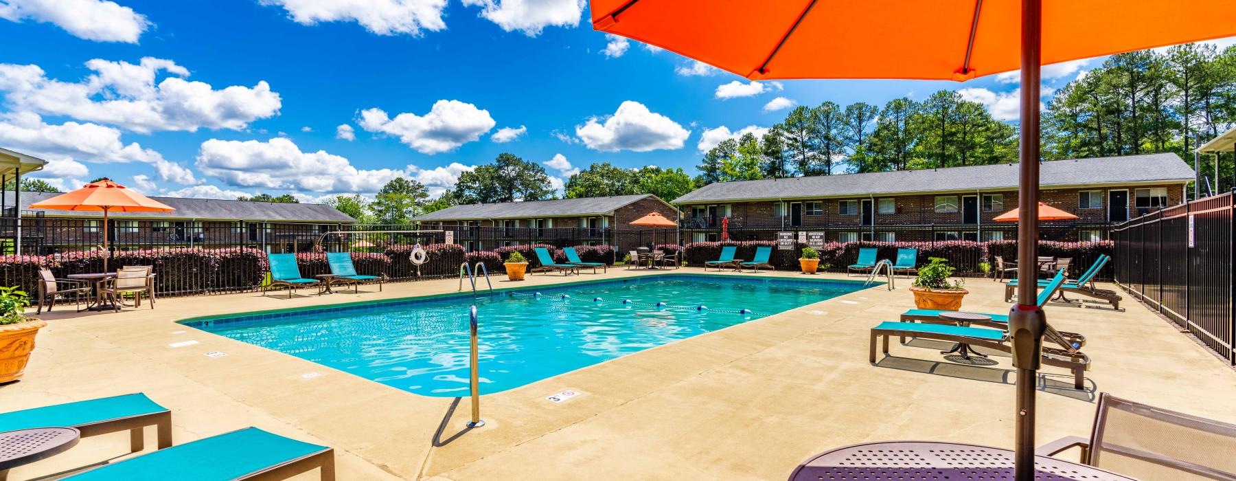 a pool with a lounge chair and umbrella