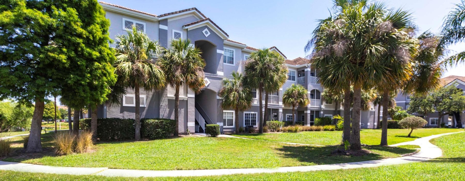 a building with palm trees and grass