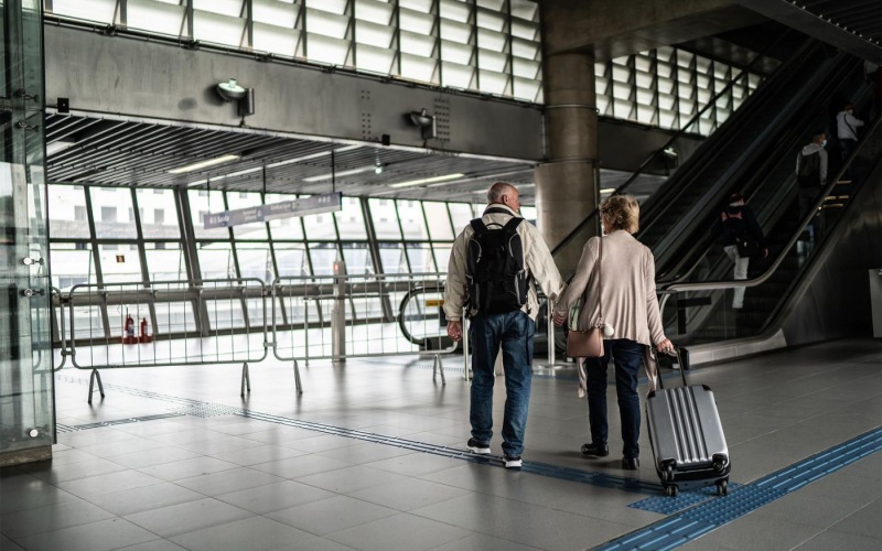 a man and a woman walking with luggage through an airport