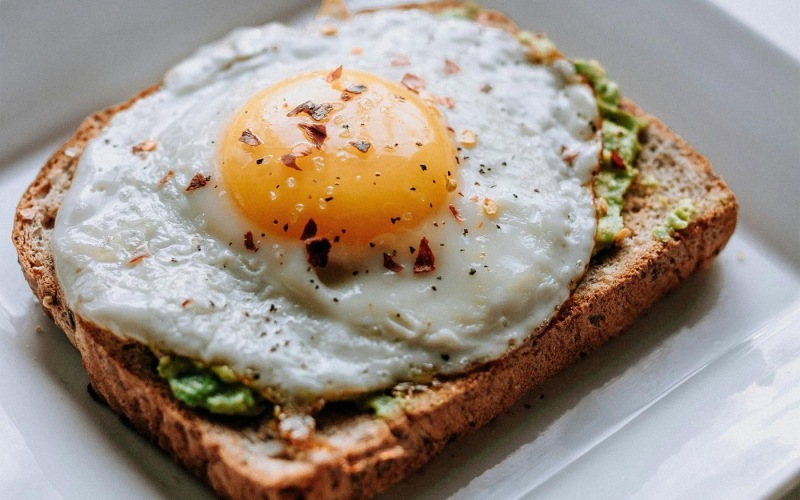 a breakfast sandwich with an egg on top
