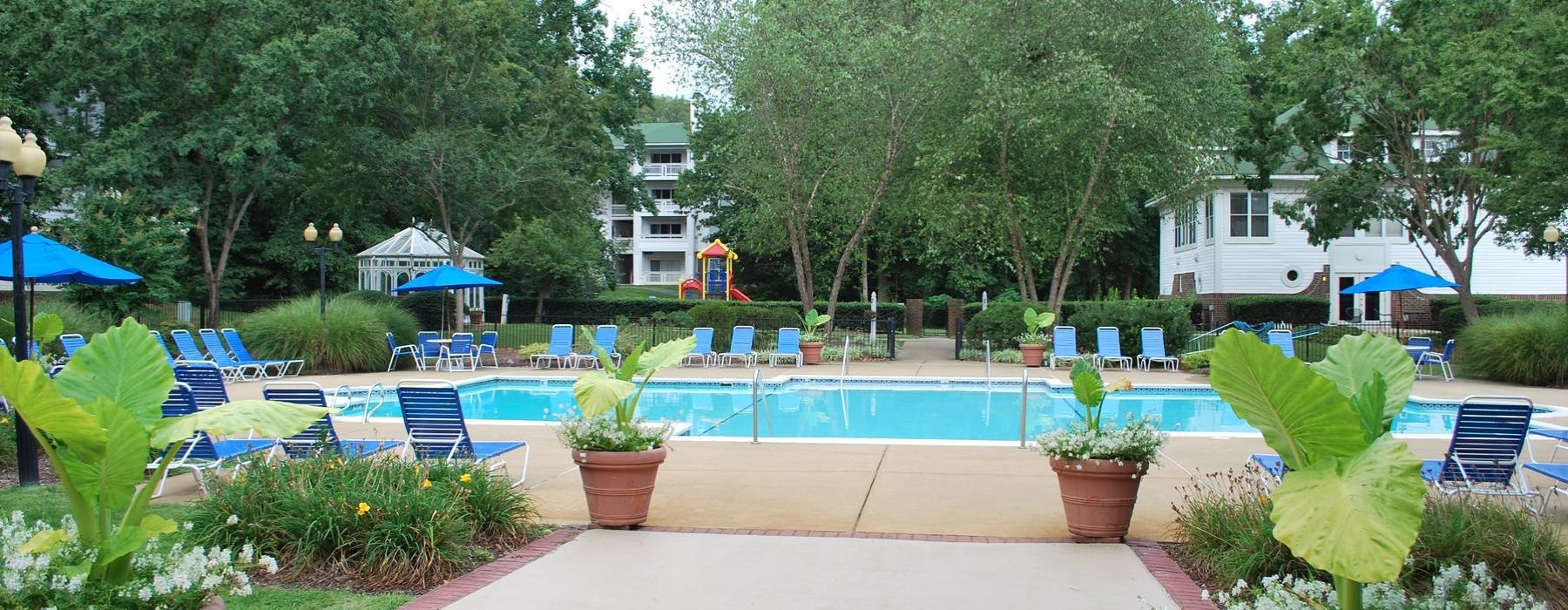 a swimming pool with chairs and umbrellas
