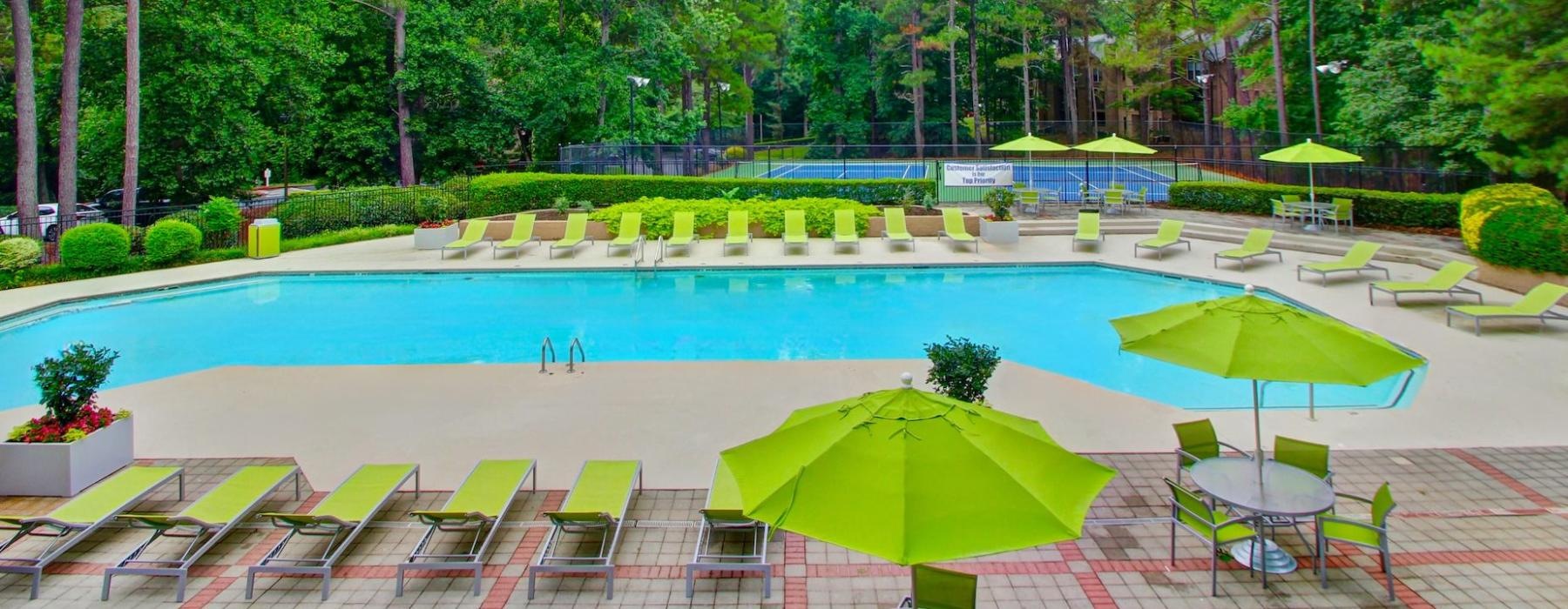 a pool with chairs and umbrellas by it
