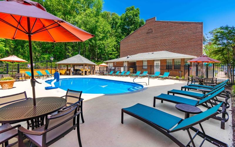 a pool with chairs and umbrellas