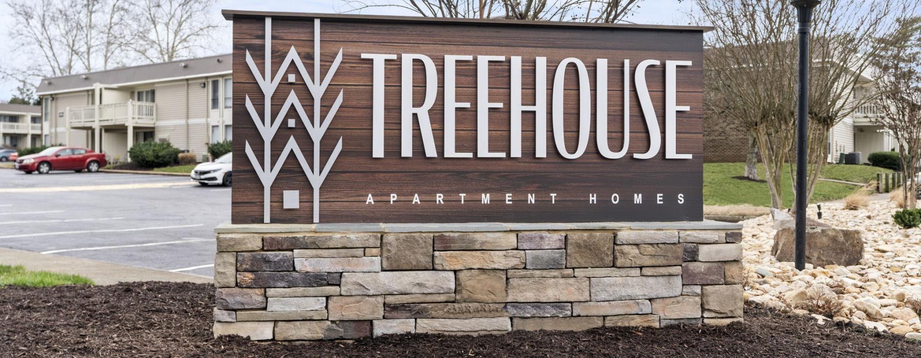 a sign on a stone wall that reads treehouse