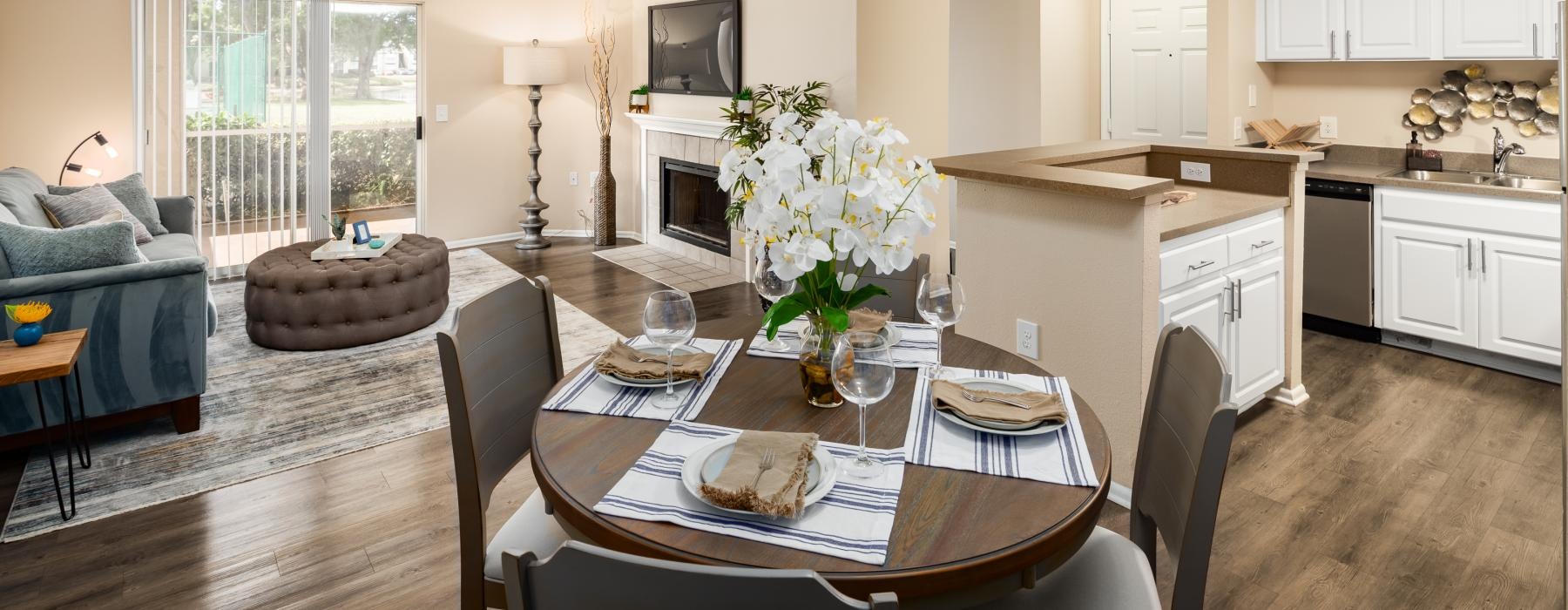 a dining room with a large table and a kitchen and living room