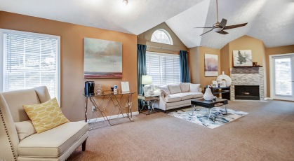 Spacious clubhouse with lots of windows, ceiling fan and fireplace