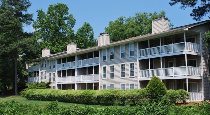 Complex exterior building stretching across lush landscaping sitting among mature trees