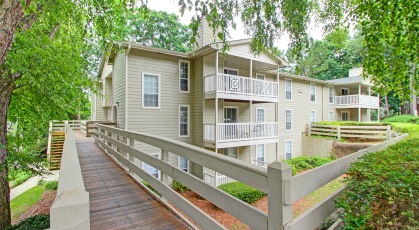 Tree shaded apartment breezeway over manicured grounds