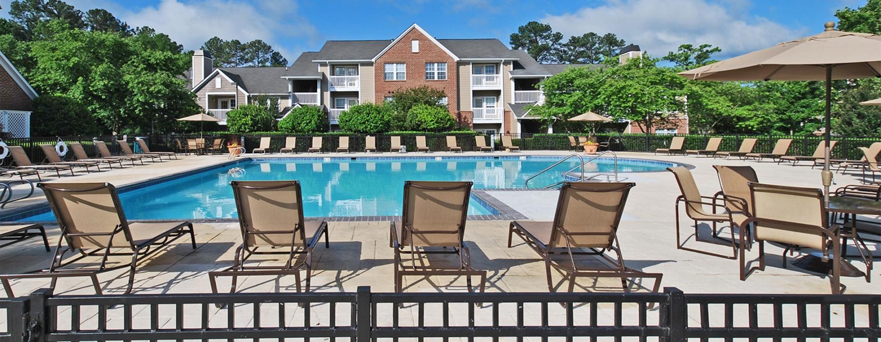 a pool with lounge chairs around it