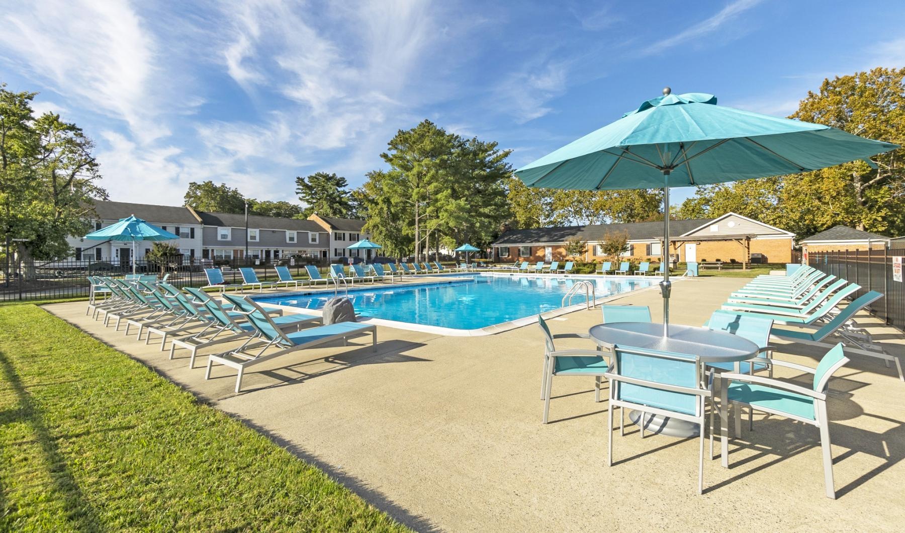 a pool with lounge chairs and umbrellas by it