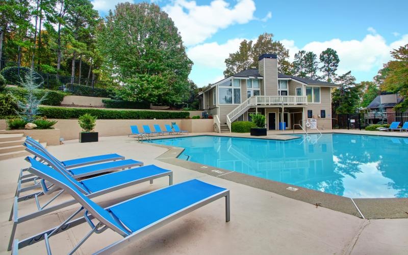 a swimming pool with a house in the background