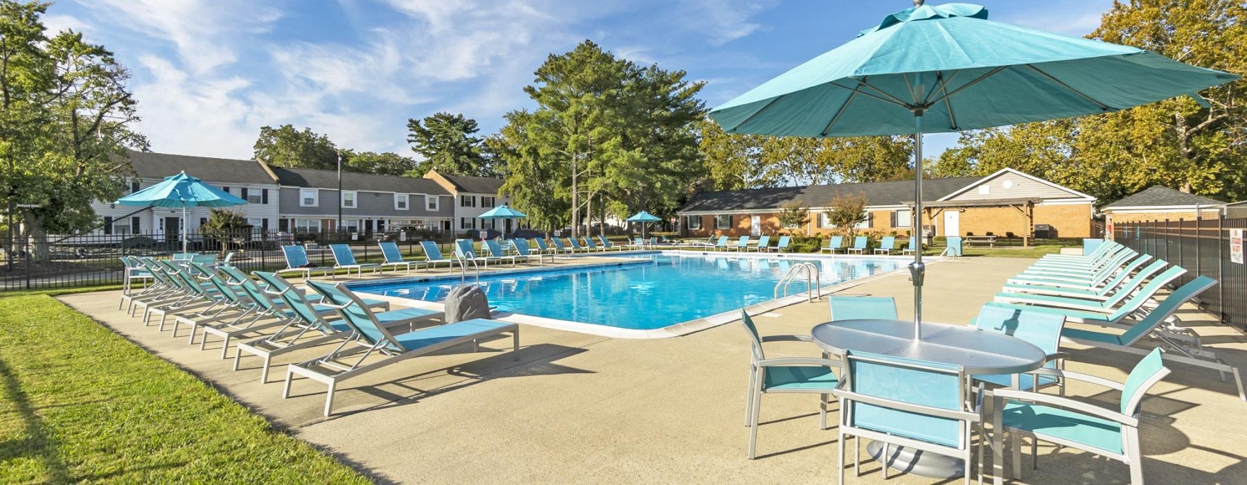a pool with lounge chairs and umbrellas by it