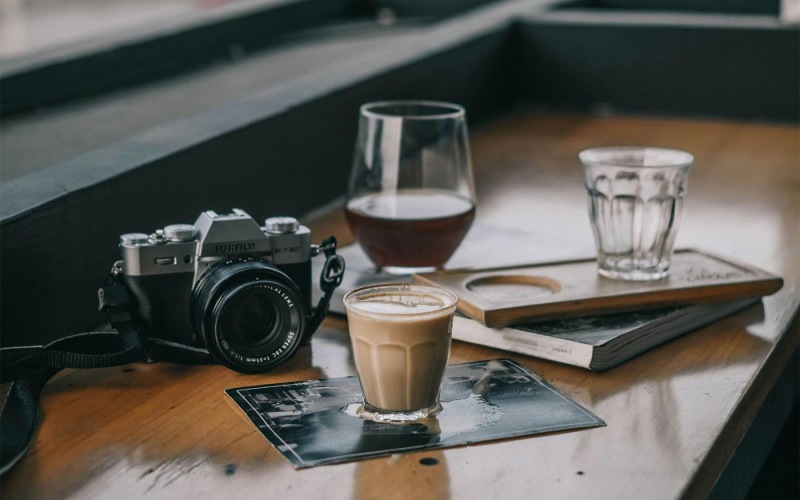a camera and cup of coffee on a table