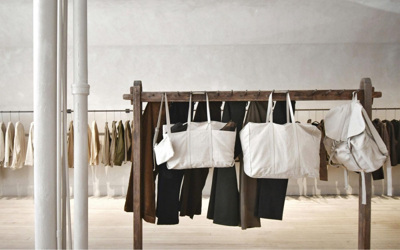 a row of clothes and bags on a rack