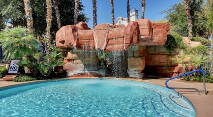 Waterfall cascading over overhanging rock ledge, into pool