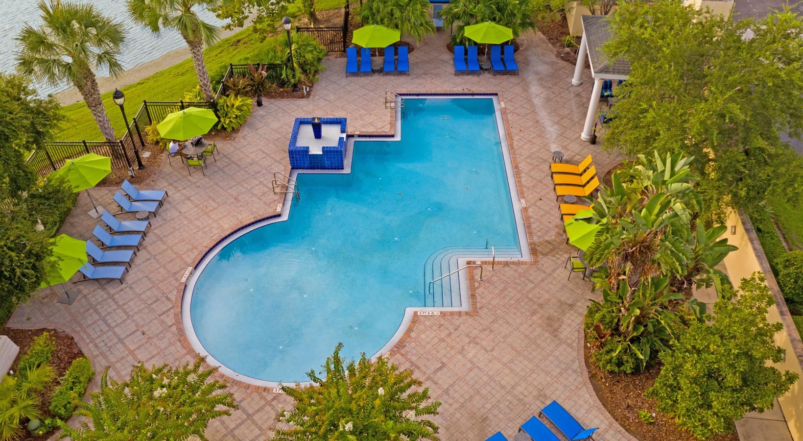 Aerial view of resort-style pool surrounded by tropical landscaping