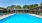outdoor swimming pool with umbrella shaded table and chairs