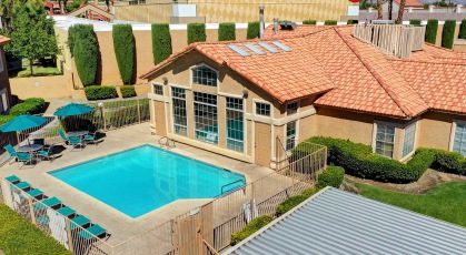 Swimming pool with umbrella shaded tables and chairs