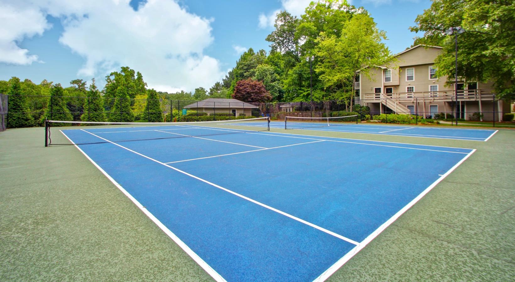 Two fenced in, outdoor tennis courts
