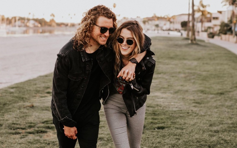 a couple walks on grassy area in open neighborhood lot