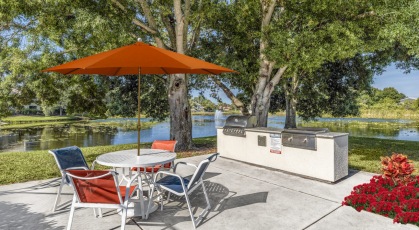 Grilling area with umbrella covered tables and chairs