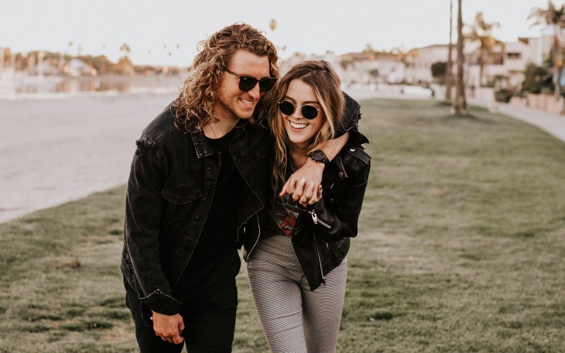 a man and a woman walking in a park