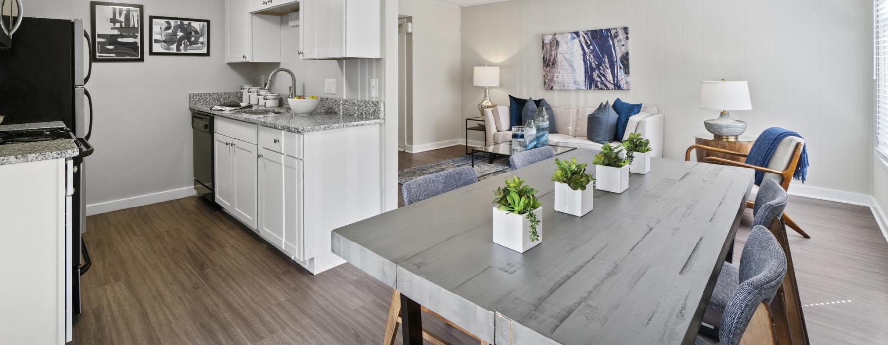 a dining room connected to a kitchen with a table and chairs