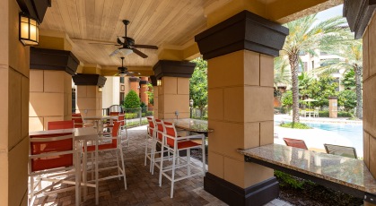 Beautiful poolside cabana with high tables and chairs and granite countertops