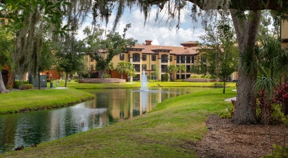 Walking trail along lake with fountain and well landscaped grounds