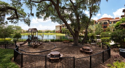 Spacious playground with climbing equipment and slides with benches and picnic tables