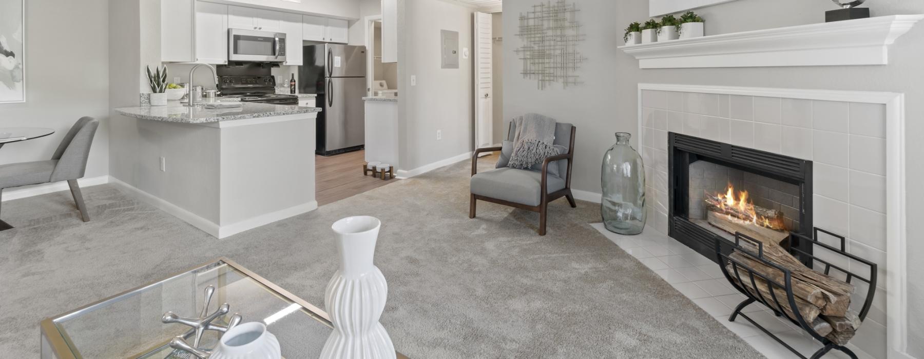 a living room with a fireplace and a breakfast island