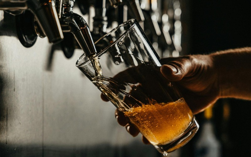 someone pouring a glass of beer