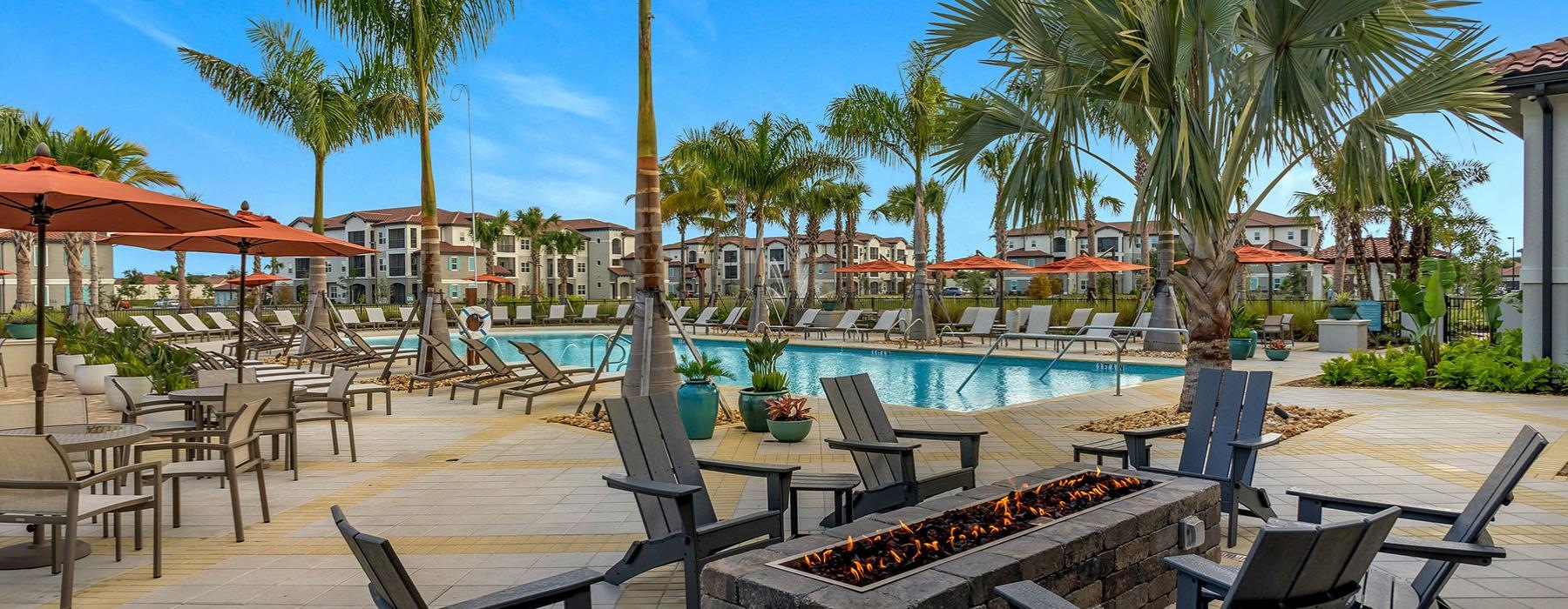 a pool with chairs and tables by it