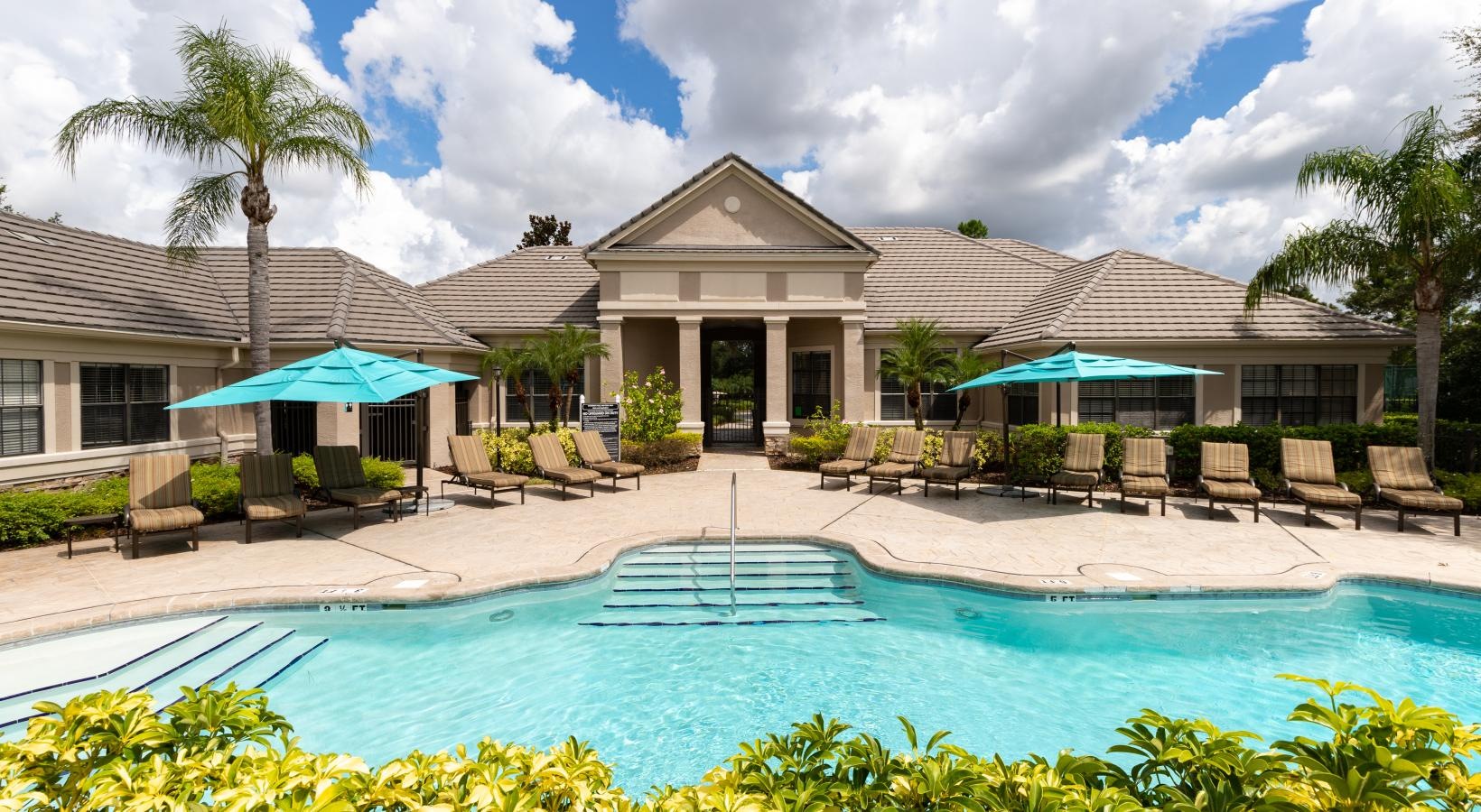 Swimming pool with lounge seating and umbrellas