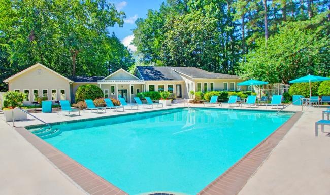 a swimming pool with chairs around it