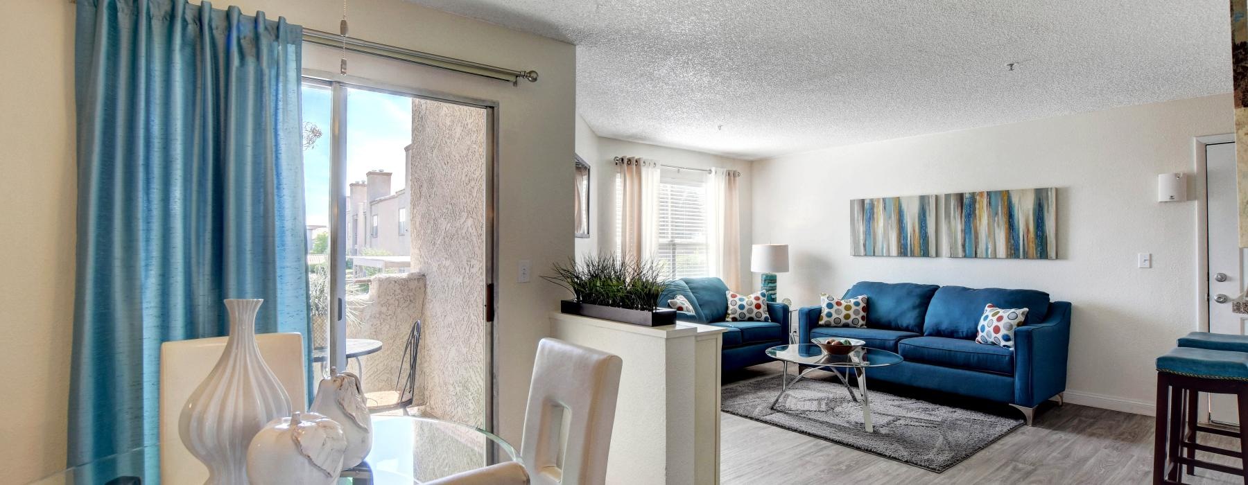 a living room with a ceiling fan and dining room table with chairs