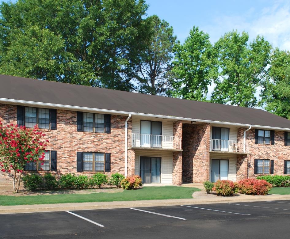 a brick building with trees in the background